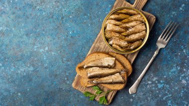 Yağlı altın lahanalar ve tahtadan yapılmış balıklı sandviçlerle dolu bir kutu.