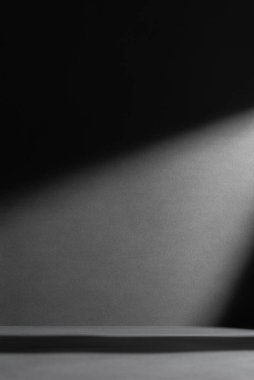 Keskin gölgeleri ve bir ışık demeti olan karanlık, dramatik bir arka plan. Yaratıcı tasarım için minimalist soyut arkaplan, gizem kavramları, karşıtlık, yalnızlık veya sinematik atmosfer.