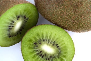 Yeşil Kiwi bütün bir izole üzerinde beyaz arka plan yanındaki ikiye böldüm