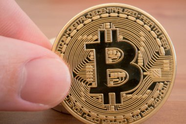 Gerçek tutan el ahşap zemin üzerine altın bitcoin