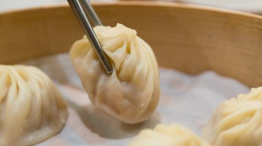 Bambu sepet içinde bir domuz Xiaolongbao Tayvanlı hamur tatlısı alarak yemek çubukları