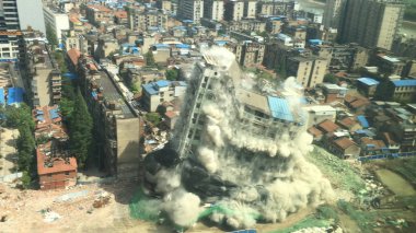 Downtown building demolition by controlled implosion in China clipart