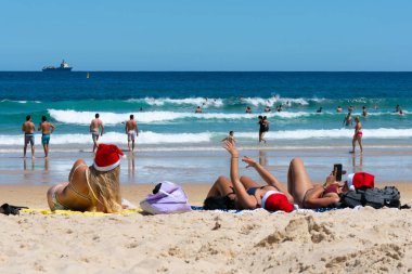 24 Aralık 2018, Bondi Sydney Australia: Bondi üzerinde Noel arifesinde Noel şapka üç genç bayanlar plaj Sydney Australia