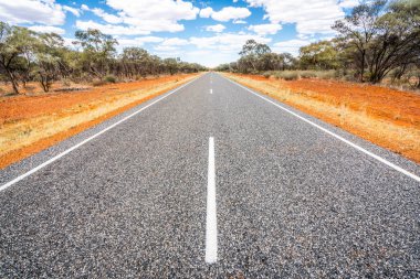 Nt Avustralya outback kırmızı merkezinin ortasında beyaz çizgiler ile düz yol