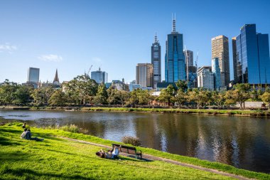 2 Ocak 2019, Melbourne Avustralya: insanlar istirahat Yarra nehir kıyısındaki mesire çim orta Melbourne ve Victoria Avustralya Melbourne Cbd manzarası