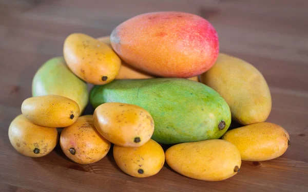 Стек из нескольких сортов манго разного размера и цвета — стоковое фото