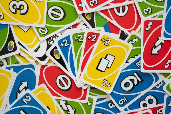 Uno 游戏卡散落在所有的框架和手中的卡 — 图库照片