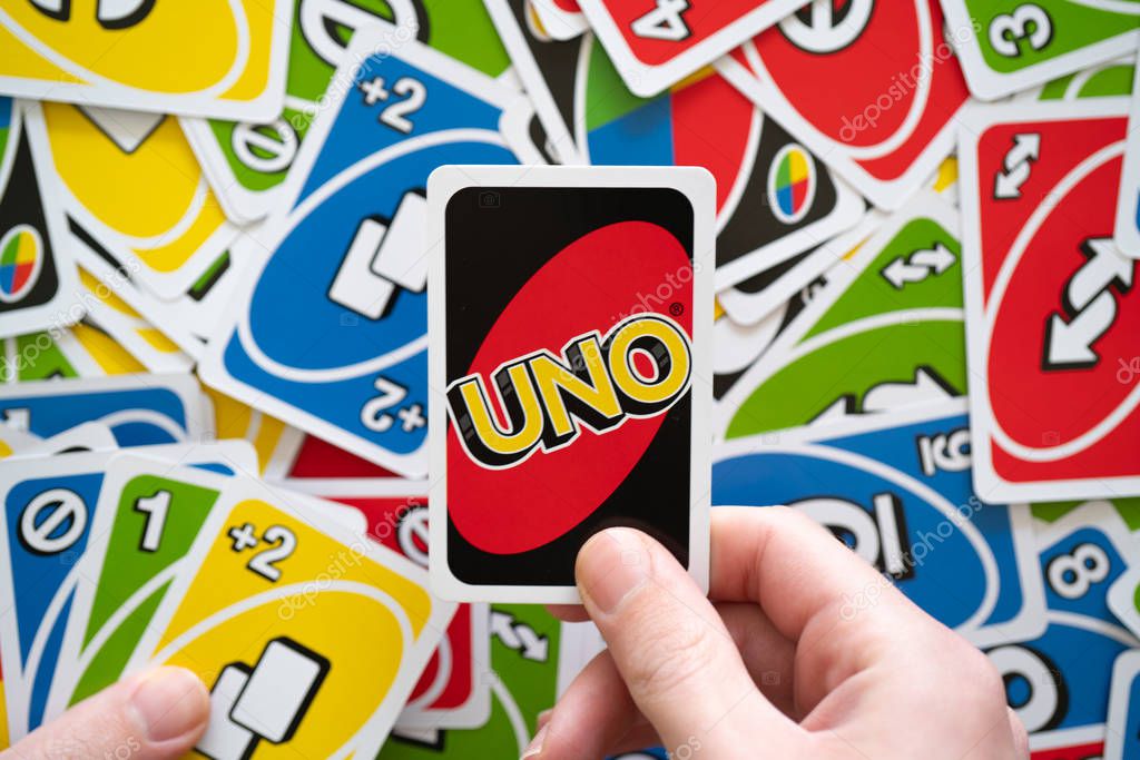 6 April 2019, Wuhan China : Man hand holding Uno game card showing the reverse of the card with Uno logo