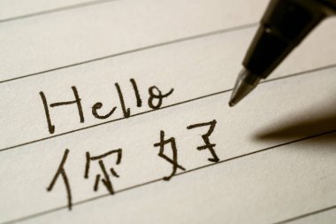 Beginner Chinese language learner writing Hello word in Chinese  clipart
