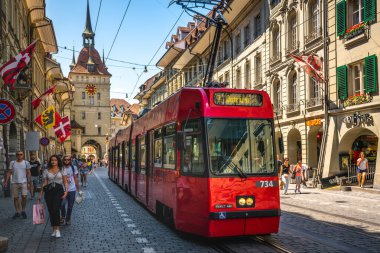 Bern İsviçre, 27 Haziran 2020: Ostring ve Kafigturm 'a giden kırmızı tramvay veya Bern' deki Marktgasse Caddesi 'ndeki eski İsviçre kentinde insanlarla birlikte hapishane kulesi