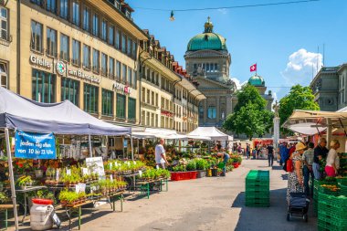 Bern İsviçre, 27 Haziran 2020: Barenplatz Meydanı 'ndaki çiftçi pazarı ve İsviçre' nin Bern kentindeki Bundeshaus federal binasındaki insanlar