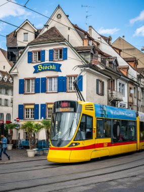 Basel İsviçre, 29 Haziran 2020: BVB şirketinin sarı tramvay ön görüntüsü ve eski İsviçre Basel kasabasındaki antik evler