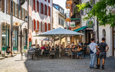 Sion Switzerland , 3 July 2020 : Bar terrace full of people on sunny summer day in pedestrian street of Sion old town Switzerland clipart