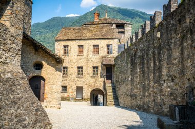 Avlu ve giriş Castello di Montebello kalesi. Arkasında bina, duvar ve dağ var. İsviçre Bellinzona Ticino 'da.