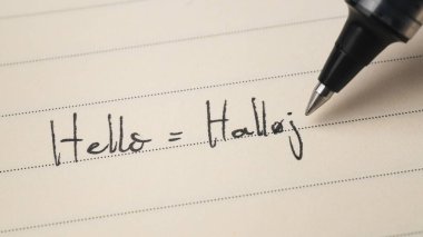 Acemi Danimarkalı dil öğrenicisi. Not defteri makro çekimi için Hello Word Halloj.