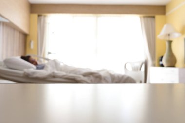 Boş beyaz yatak hastane tablo arka plan bulanık kadın hasta hastane yatağında hafif bir gün ile yatan ile üzerinden. İç hastane, klinik, sağlık ve tıp için arka plan.