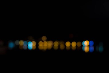 Geceleri deniz üzerine yansıtan ışık soyut bokeh.