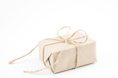 Noel, yeni yıl ve Sevgililer günü hediyesi kutlama veya yıldönümü kavramı için beyaz arka plan üzerinde izole kahverengi ip yay kurdele ile bağlanmış vintage kahverengi craft kağıt hediye kutusu.