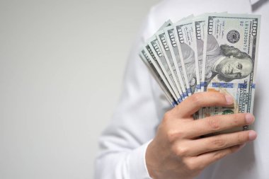 Bizi dolar para beyaz arka plan üzerinde elinde tutan bir iş adamı. Yatırım, mali ve başarılı iş kavramı USD faturaları.