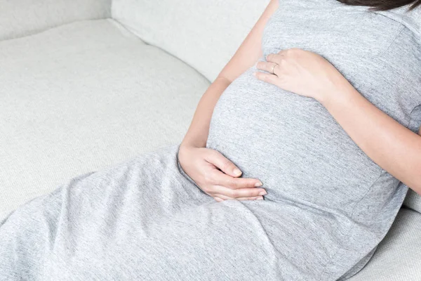 Zbliżenie Dłoni Młoda Piękna Kobieta Ciąży Dotykając Jej Brzuch Siedząc — Zdjęcie stockowe