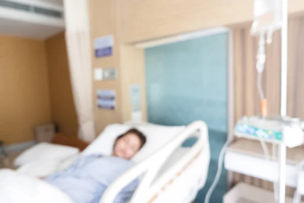 Kadın hasta yatağında hastanede VIP Oda tuzlu çözüm damlalıkla yalan arka plan bulanık IV sıvı intravenöz damla ayarlayın. Ameliyattan sonra acil durum kurtarma. Sağlık ve tıp kavramı.