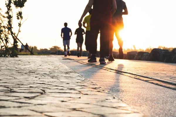 Runner bulanık grup akşam günbatımında parkta yayınlanıyor. İnsanlar yürürken, insanlar ve egzersiz. Fitness ve sağlıklı faaliyet yaşam tarzı.