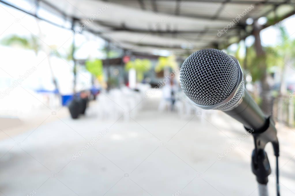 Close up Microphone on abstract blurred background of speech seminar, meeting, event in outdoor restaurant. Party and mini concert on beach.