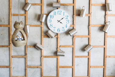 Ahşap çerçeve satır arkaplanı ile çıplak beton duvara Vintage saat ve geri dönüşümlü kutular ile dekore edilmiş ve kedi bebek asılı. Vintage ve çatı katı tarzında atıkların geri dönüşümü ile iç cephe dekorasyon.