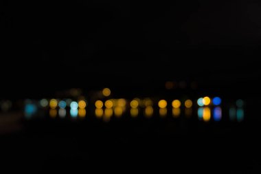 Geceleri deniz üzerine yansıtan ışık soyut bokeh.