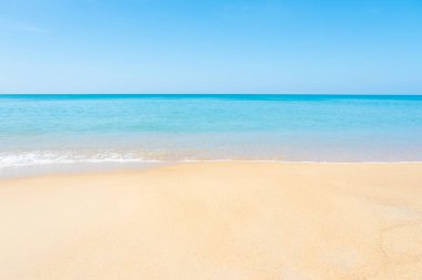 Güzel kumlu plajı ve tropikal deniz yaz gün mavi gökyüzü ile. Sakin yaz deniz sakin dalga uyumunu. Güneşli gökyüzü ve sakin mavi okyanus. Ufukta bulutlar canlı deniz. Doğa ve açık.