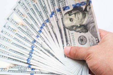 Beyaz arka plan üzerinde izole yüz dolar faturaları para tutan el kapatın. El yüz dolarlık banknot para finans, para değişimi ve bağış kavramları vererek..