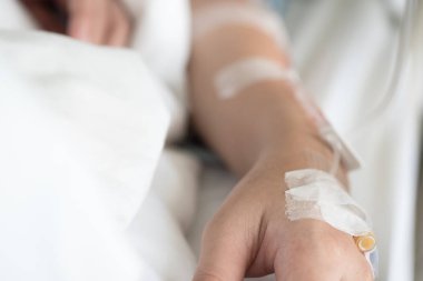 Seçici odak Tuzlu Çözüm intravenöz enjeksiyon tarafından alma kadın hastanın yandan tedavi sıvı replasman tedavisi hastanede VIP odasında olun. Tıbbi tedavi, sağlık ve acil hasta bakımı.