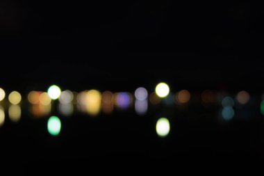 Geceleri deniz üzerine yansıtan ışık soyut bokeh.