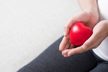 Genç ve aşk kırmızı kalp el karnının önünde tutan mutlu hamile kadın. Annenin kalp sağlık, umut ve bekliyor, insanlar, ebeveynlik, Aile ve sağlık kavramı.
