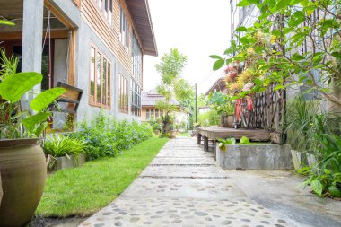 Peyzaj Bahçe. Tropikal bahçe taş yolu. Taş yürüyüş yolu çimento ve çakıl kırsalında yeşil çim ile yapılmış. Açık bahçe dış tasarım.