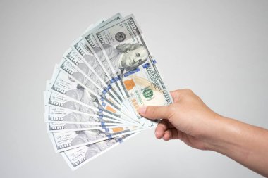 Bize dolar faturaları para beyaz arka plan üzerinde elinde. Holding ya da birçok yüz dolarlık banknot mali ya da bağış kavramı veren işadamı el kadar kapatın.