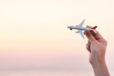  Tatil uçak model günbatımı gökyüzü ve yaz deniz arka plan hayalleri yolculuk tutan kadın el. Seyahat ve hava ulaşım kavramı. Uçuş ve kalkış, el ile küçük oyuncak uçak.