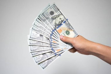 Bize dolar faturaları para beyaz arka plan üzerinde elinde. Holding ya da birçok yüz dolarlık banknot mali ya da bağış kavramı veren işadamı el kadar kapatın.