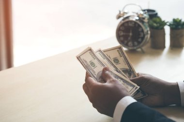 Bizi para para elinde tutan mutlu ve başarılı bir iş adamı. El gösterme ve para yatırım, başarı, özgürlük, mali umutları, kariyer gelişme kavramı Danışma üzerinde saymak.