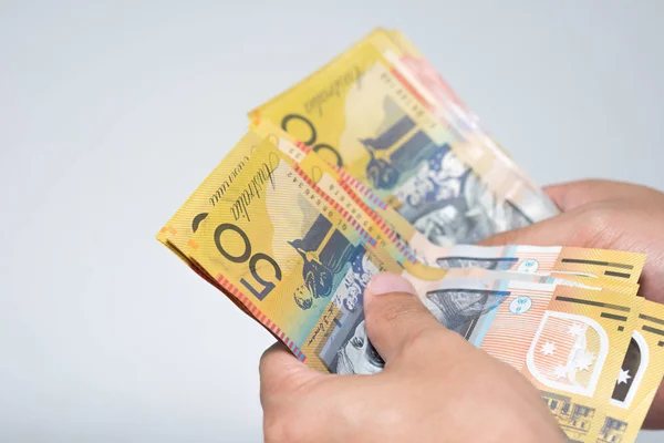 商人手里数着五十澳元钞票 被孤立在灰色背景下 在货币兑换和付款概念上持有或给予澳大利亚货币纸币 — 图库照片