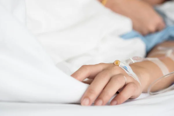 Seçici odak Tuzlu Çözüm intravenöz enjeksiyon tarafından alma kadın hastanın yandan tedavi sıvı replasman tedavisi hastanede VIP odasında olun. Tıbbi tedavi, sağlık ve acil hasta bakımı.