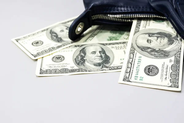 100 ドル札はお金を使う贅沢なコンセプトの灰色の背景に暗いブルー レディース ハンドバッグから落ちた — ストック写真
