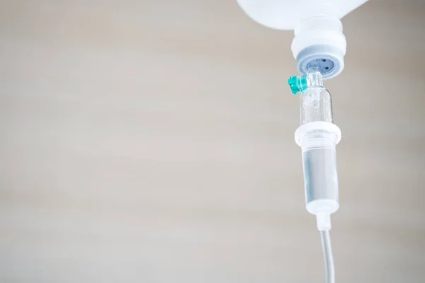 门诊和静脉输液泵的盐水溶液在医疗 医疗保健和急诊病人护理中的应用在医院 Vip 室的木质背景 — 图库照片