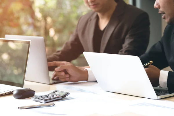 Seçici odak. Dizüstü bilgisayar kullanarak ve Ofis Toplantı sırasında ekranda gösteren iki genç iş ortağı. Başlangıç işadamları internet iş projesi için online fikir üzerinden seyir tartışıyor.