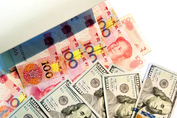 伪造美元货币检测 在白色背景下用紫外光或黑光机检查100美元和人民币纸币 — 图库照片
