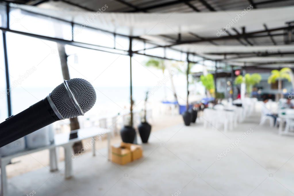 Close up Microphone on abstract blurred background of speech seminar, meeting, event in outdoor restaurant. Party and mini concert on beach.