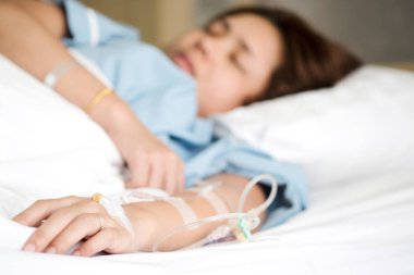 Seçici odak Tuzlu Çözüm intravenöz enjeksiyon tarafından alma kadın hastanın yandan tedavi sıvı replasman tedavisi hastanede VIP odasında olun. Tıbbi tedavi, sağlık ve acil hasta bakımı.