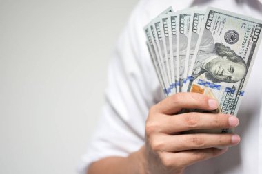 Bizi dolar para beyaz arka plan üzerinde elinde tutan bir iş adamı. Yatırım, mali ve başarılı iş kavramı USD faturaları.