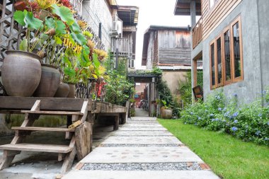 Peyzaj Bahçe. Tropikal bahçe taş yolu. Taş yürüyüş yolu çimento ve çakıl kırsalında yeşil çim ile yapılmış. Açık bahçe dış tasarım.