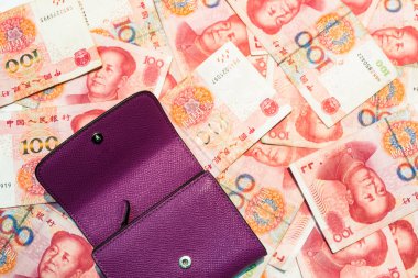 Purple wallet placed on Chinese yuan banknotes, Money concept background. clipart
